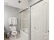 This bathroom features a shower with glass doors, white tile, and a toilet with hand towel rack at 315 Arlington Ave # 1104, Charlotte, NC 28203