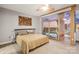 This main bedroom has gray walls, a ceiling fan and a sliding glass door with views of the city at 315 Arlington Ave # 1104, Charlotte, NC 28203