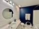 Bathroom showcasing a white vanity, round mirror, shiplap wall, and tub with shower at 3619 Whitney Way, Terrell, NC 28682