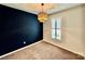 Cozy bedroom featuring dark accent wall, neutral carpet, large window with shutters and modern lighting at 3619 Whitney Way, Terrell, NC 28682