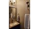 Cozy powder room featuring a vanity with a granite countertop, decorative mirror, and wall-mounted sconces at 400 Antlers Ct, Gastonia, NC 28052