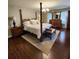 Spacious bedroom with a four-poster bed, wood floors, and natural light streaming through sheer curtains at 400 Antlers Ct, Gastonia, NC 28052