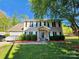 Charming two-story home with manicured landscaping, featuring a covered front porch, neutral siding, and dark shutters at 400 Antlers Ct, Gastonia, NC 28052