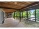 Exterior view of a spacious covered deck, overlooking a yard with lush trees and lake views at 4749 16Th Street Ne Dr, Hickory, NC 28601