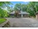 A gray wood-sided home with stone chimney, skylights, mature trees, and a paved driveway for easy access at 4749 16Th Street Ne Dr, Hickory, NC 28601