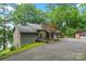 Charming home with stone chimney, skylights, and a paved driveway leading to an attached garage and wooded surroundings at 4749 16Th Street Ne Dr, Hickory, NC 28601