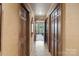 Hallway with wood paneled walls and floors and a view into a room with large windows at 4749 16Th Street Ne Dr, Hickory, NC 28601