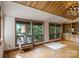 Living room featuring a wood ceiling, hardwood floors, many windows, and custom built-in cabinets at 4749 16Th Street Ne Dr, Hickory, NC 28601
