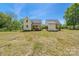 A picturesque backyard features a well-manicured lawn and white home with a covered porch at 5028 Lewis Rd, Gastonia, NC 28052