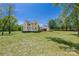 A large backyard features a white home, a large lawn, and mature trees at 5028 Lewis Rd, Gastonia, NC 28052