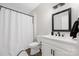 A well-lit bathroom features a shower with a white curtain and a white vanity at 5028 Lewis Rd, Gastonia, NC 28052