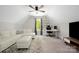 Spacious bonus room featuring a large white sectional, ceiling fan and dedicated desk area at 5028 Lewis Rd, Gastonia, NC 28052