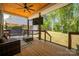 Relaxing covered patio with wood ceiling, ceiling fan, outdoor seating, television and view of the backyard at 5028 Lewis Rd, Gastonia, NC 28052