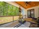 Comfortable covered patio with wood ceiling, ceiling fan, cozy seating, and a serene backyard view at 5028 Lewis Rd, Gastonia, NC 28052