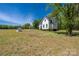 A white farmhouse with black trim has a large backyard with a shed at 5028 Lewis Rd, Gastonia, NC 28052