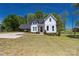 A two-story white farmhouse with a well-manicured front lawn, car port, and plenty of land at 5028 Lewis Rd, Gastonia, NC 28052