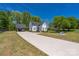 A long driveway leads to a stunning white farmhouse with a matching carport at 5028 Lewis Rd, Gastonia, NC 28052