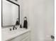 Well-lit powder room featuring modern black fixtures, a sleek mirror and a towel ring at 5028 Lewis Rd, Gastonia, NC 28052