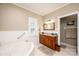 A lovely bathroom with a large soaking tub, granite counters, and white tiled floors at 5933 Flintlock Ct, Hickory, NC 28601