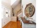 Bright foyer with hardwood floors, staircase, entry door, and decorative mirror at 5933 Flintlock Ct, Hickory, NC 28601