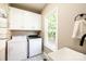 Bright laundry room with white cabinets, a large sink, washer and dryer at 5933 Flintlock Ct, Hickory, NC 28601