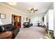 Cozy living area featuring carpet, a ceiling fan, and an opening into an adjacent kitchen at 5933 Flintlock Ct, Hickory, NC 28601