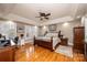 Main bedroom boasts gleaming hardwood floors, shutters, and tray ceiling with fan at 5933 Flintlock Ct, Hickory, NC 28601