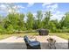 Relaxing back patio featuring a hammock, grill and comfortable chair surrounded by lush greenery at 6040 Fazio Ct, Harrisburg, NC 28075