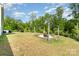 Spacious back yard with a charming pergola-covered fire pit and an outdoor seating area at 6040 Fazio Ct, Harrisburg, NC 28075