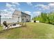 Large back yard with a fire pit area, a patio with seating, and a well-manicured lawn at 6040 Fazio Ct, Harrisburg, NC 28075