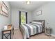 Cozy bedroom featuring a gray upholstered bed with stylish bedding, neutral walls, and natural light at 6040 Fazio Ct, Harrisburg, NC 28075