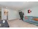 Large bonus room with laundry area, blue sofa with orange pillows, and exercise equipment for a versatile space at 6040 Fazio Ct, Harrisburg, NC 28075