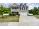 Charming two-story home with a welcoming front porch, attached garage, and well-maintained landscaping at 6040 Fazio Ct, Harrisburg, NC 28075