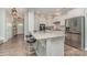 Bright kitchen features an island with seating, granite countertops, stainless steel appliances, and ample cabinet space at 6040 Fazio Ct, Harrisburg, NC 28075