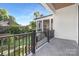 A modern balcony with black metal railings, gray stone floors, and a view of the lawn and trees at 632 Dorothy Dr, Charlotte, NC 28203