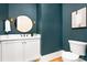 Stylish powder room featuring a round mirror, sconces, and blue walls at 632 Dorothy Dr, Charlotte, NC 28203