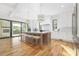 Bright kitchen with white cabinets, hardwood floors, island seating and access to outdoor deck at 632 Dorothy Dr, Charlotte, NC 28203