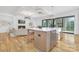 Bright kitchen with white cabinets, hardwood floors, and island seating overlooking living room at 632 Dorothy Dr, Charlotte, NC 28203