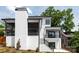 Back exterior view with white brick chimney, two stories, rear porch, stairs and black railings at 632 Dorothy Dr, Charlotte, NC 28203