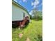Side exterior view with a red staircase leading to a door, surrounded by lush greenery at 645 E Border E Rd, Rock Hill, SC 29730