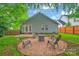 Backyard fire pit area featuring outdoor seating, string lights, and lush green grass at 7328 Starvalley Dr, Charlotte, NC 28210