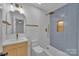 Modern bathroom featuring blue herringbone tile in the shower, a sleek vanity, and gold fixtures at 7328 Starvalley Dr, Charlotte, NC 28210