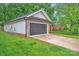 Spacious two-car garage with modern door, exterior stone accents, and concrete driveway at 7328 Starvalley Dr, Charlotte, NC 28210