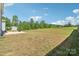 Expansive backyard featuring a concrete patio, green space, and a wooded treeline at 804 Yorkshire Dr, Albemarle, NC 28001