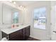 Bright bathroom featuring a double sink vanity, large mirror, and natural light from the window at 804 Yorkshire Dr, Albemarle, NC 28001