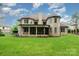 Large brick home with a covered patio and expansive green lawn in the backyard at 925 Giacomo Dr, Waxhaw, NC 28173