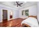 Light-filled bedroom features hardwood floors, a tray ceiling, and access to an en-suite bathroom at 925 Giacomo Dr, Waxhaw, NC 28173