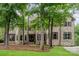 Stately stone and brick home featuring multiple windows, a lush front lawn and mature shade trees at 925 Giacomo Dr, Waxhaw, NC 28173
