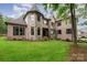Stunning brick and stone home with architectural details, manicured landscaping, and lush green lawn at 925 Giacomo Dr, Waxhaw, NC 28173
