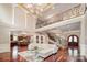 Grand foyer with staircase, dark wood floors, and open floorplan into kitchen at 925 Giacomo Dr, Waxhaw, NC 28173